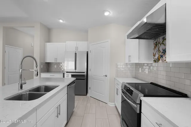 a kitchen with a sink cabinets and stainless steel appliances