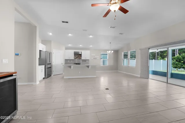 a view of a living room a kitchen and windows