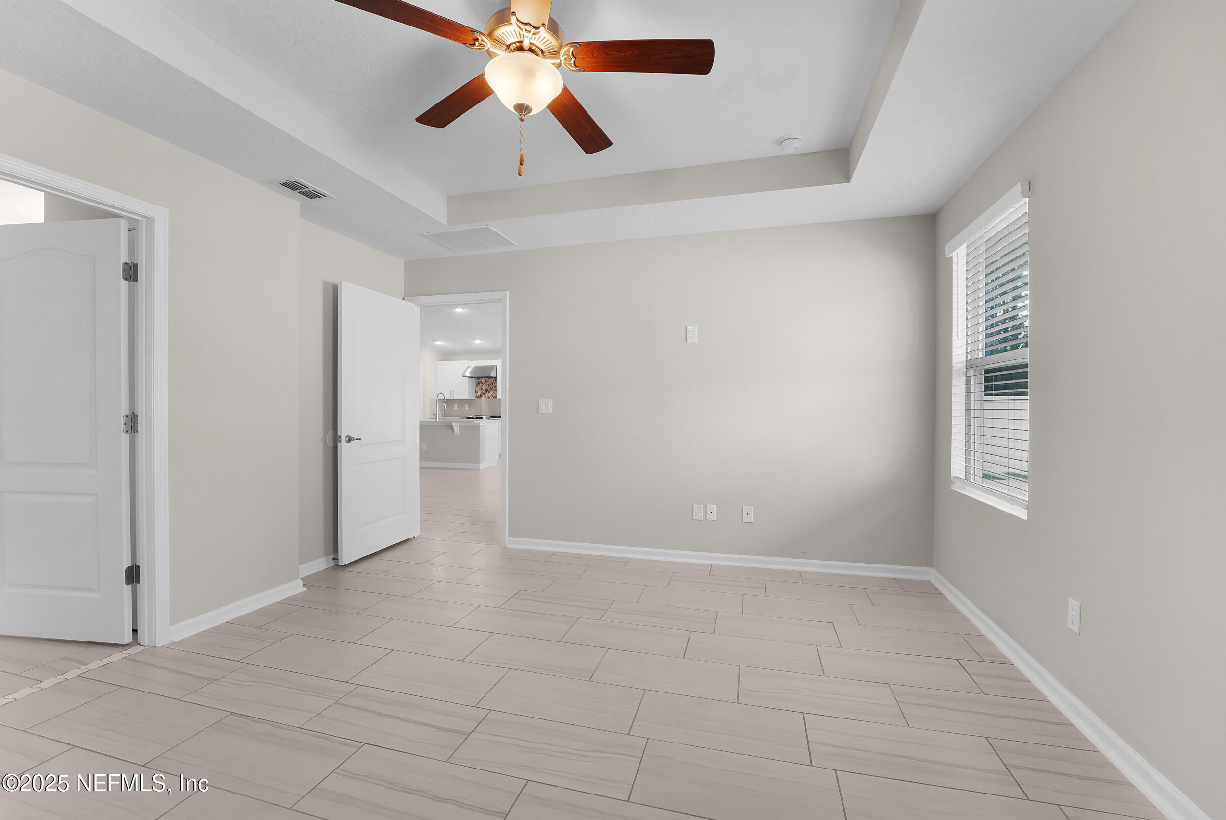 516 Lumpkin Street Jacksonville, FL 32222 - Photo 18 of 45 an empty room with chandelier fan and windows