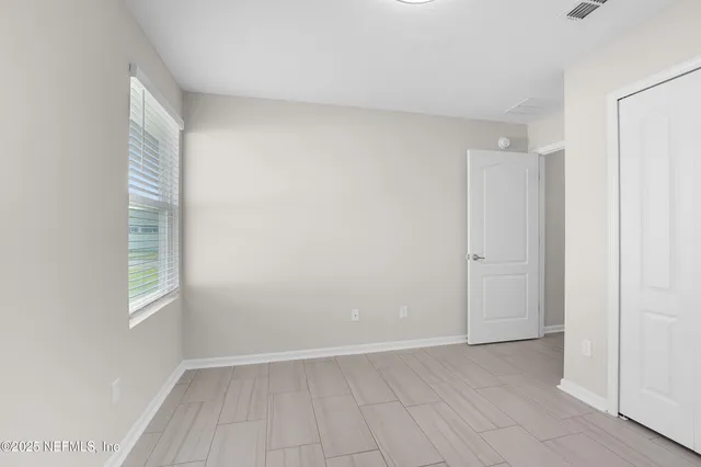 an empty room with windows and closet
