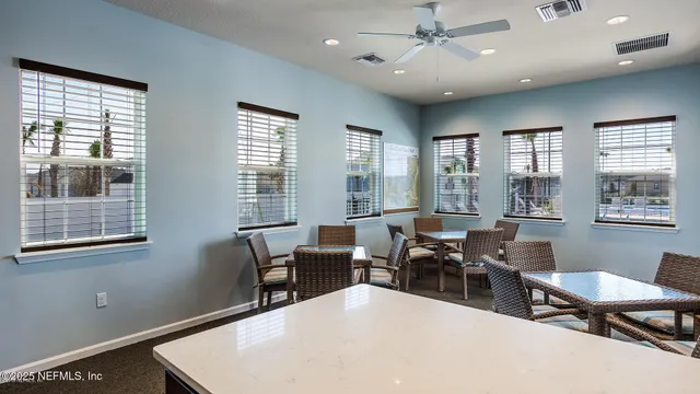 a living room with furniture two window and wooden floor