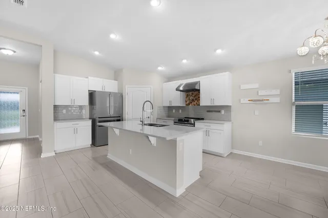 a kitchen with white cabinets and stainless steel appliances