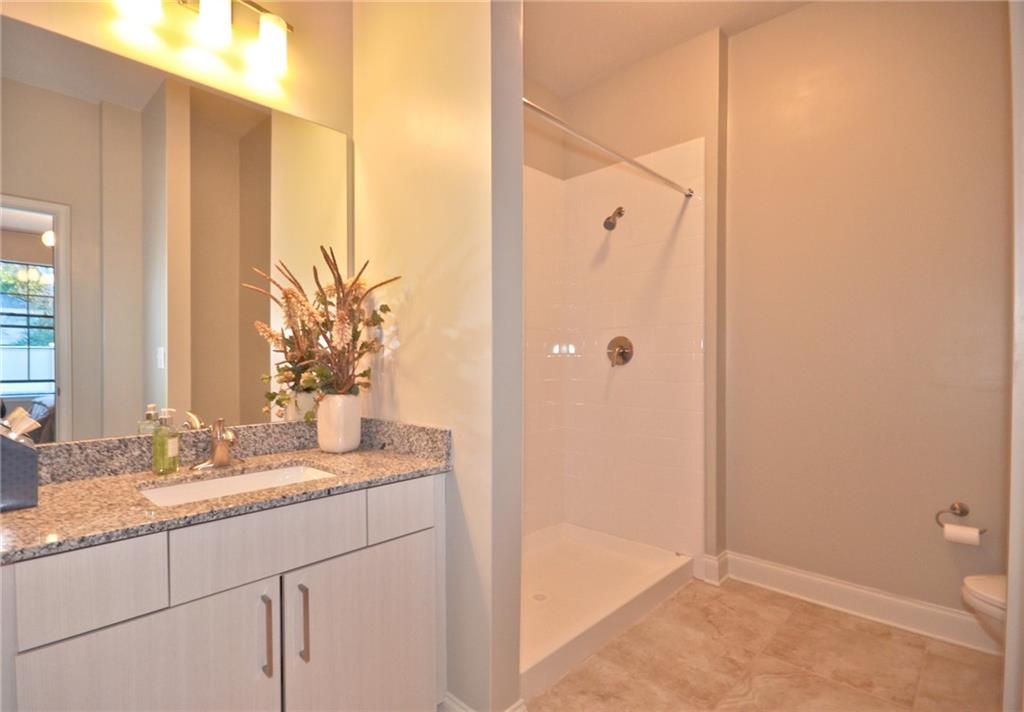 4011 Roswell Road, Unit 2311 Atlanta, GA 30342 - Photo 19 of 39 a bathroom with a granite countertop sink and a mirror