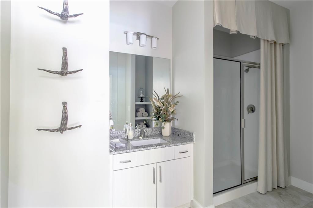 4011 Roswell Road, Unit 2311 Atlanta, GA 30342 - Photo 20 of 39 a bathroom with a granite countertop sink a mirror and vanity