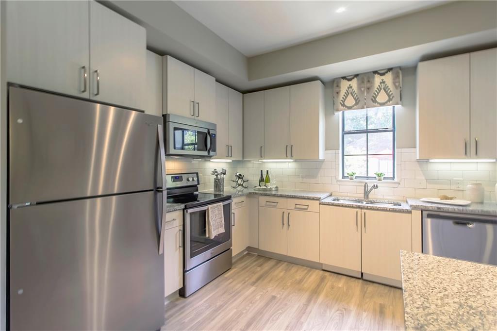 4011 Roswell Road, Unit 2311 Atlanta, GA 30342 - Photo 2 of 39 a kitchen with granite countertop stainless steel appliances a refrigerator a sink cabinets and a window