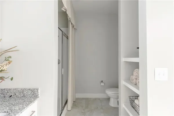 a bathroom with a granite countertop toilet and a sink
