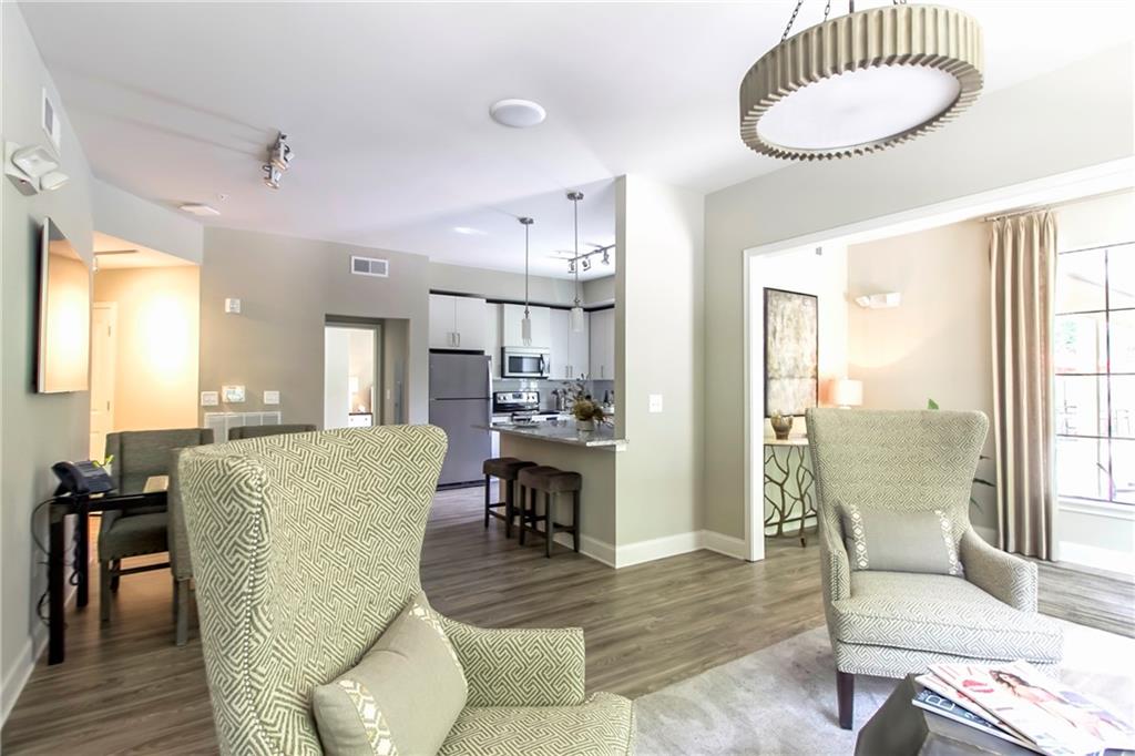 4011 Roswell Road, Unit 2311 Atlanta, GA 30342 - Photo 24 of 39 a living room with furniture a wooden floor and a large window
