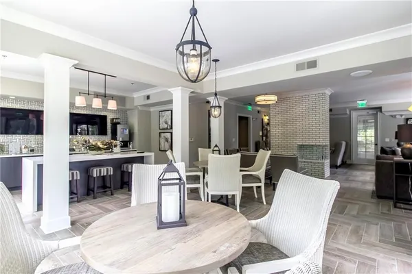 a dining room with stainless steel appliances kitchen island granite countertop a table chairs and a view of living room