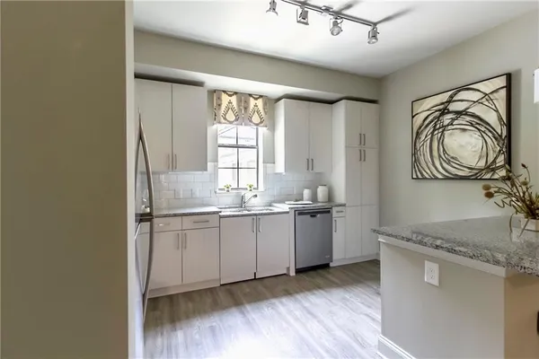 a kitchen with granite countertop a sink and a stove top oven