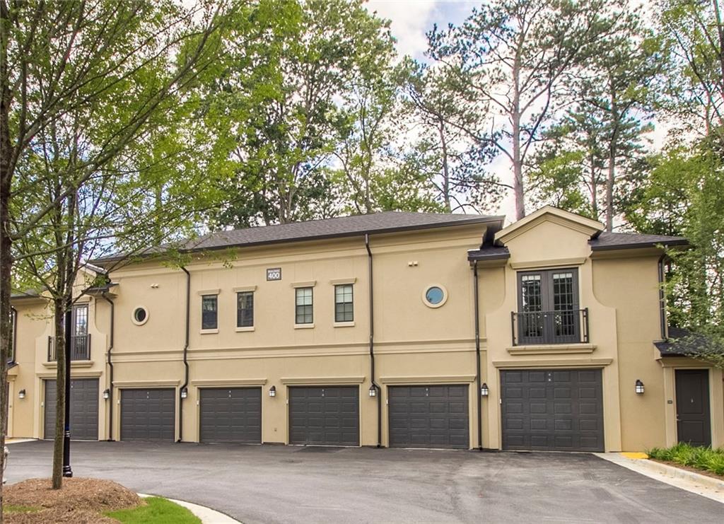 4011 Roswell Road, Unit 2311 Atlanta, GA 30342 - Photo 36 of 39 a view of a white house with large windows and a large tree