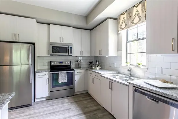 a kitchen with a sink stove microwave and refrigerator