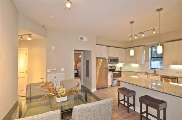 a living room with stainless steel appliances kitchen island granite countertop furniture and a view of kitchen