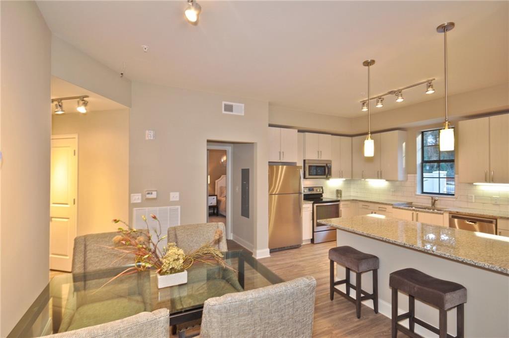 4011 Roswell Road, Unit 2311 Atlanta, GA 30342 - Photo 5 of 39 a living room with stainless steel appliances kitchen island granite countertop furniture and a view of kitchen