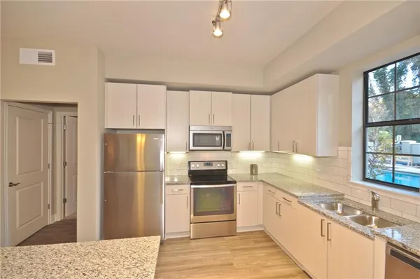 a kitchen with granite countertop a refrigerator and a sink