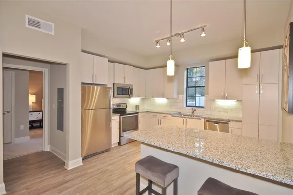 a kitchen with stainless steel appliances granite countertop a refrigerator and a sink