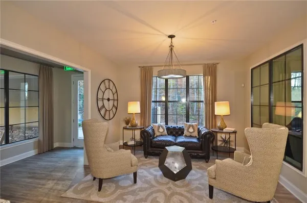 a living room with furniture two window and wooden floor