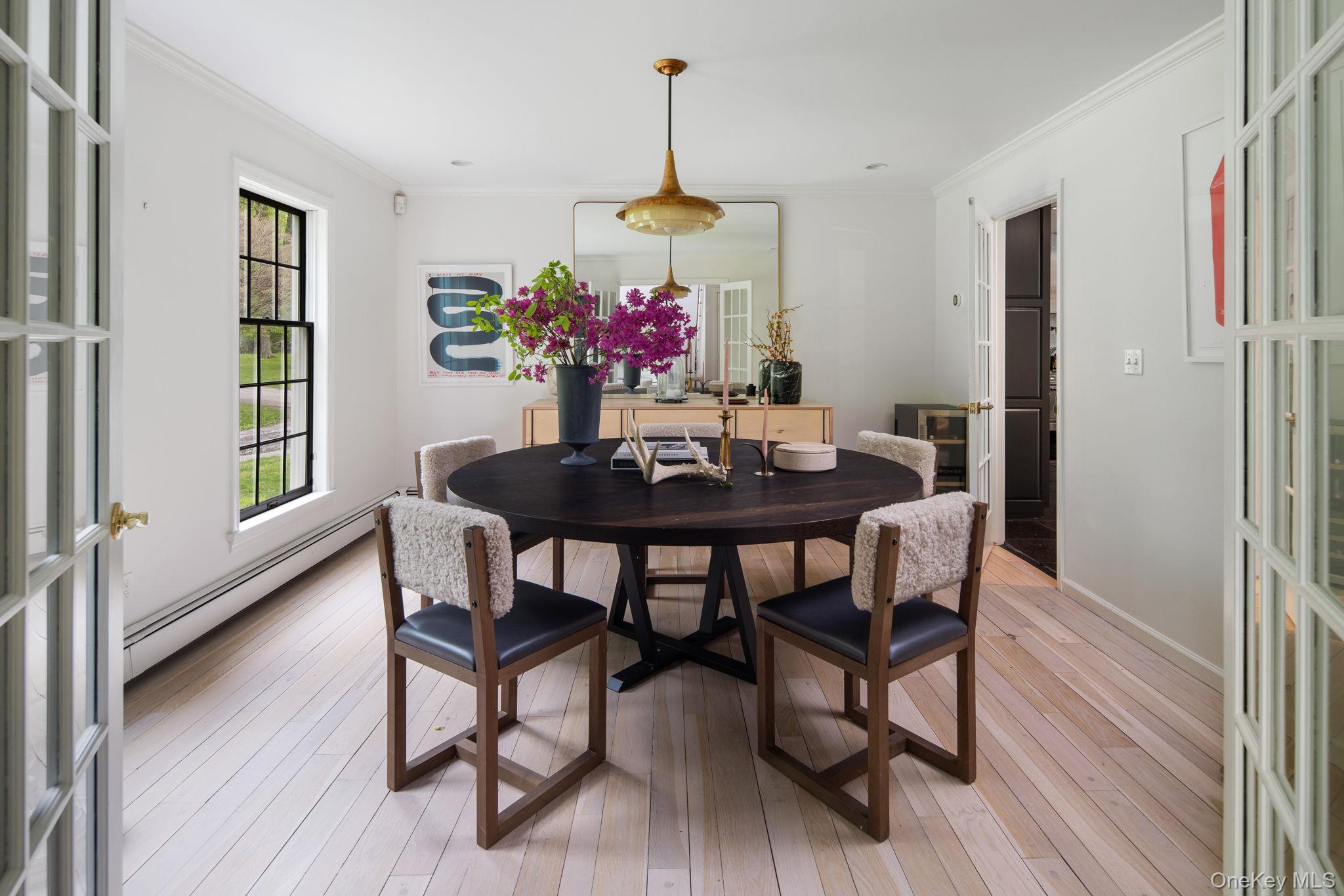 240 Eastwoods Road Pound Ridge, NY 10576 - Photo 8 of 13 a dining room with furniture potted plants and wooden floor