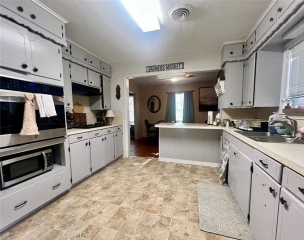 a kitchen with stainless steel appliances kitchen island granite countertop a stove sink and cabinets