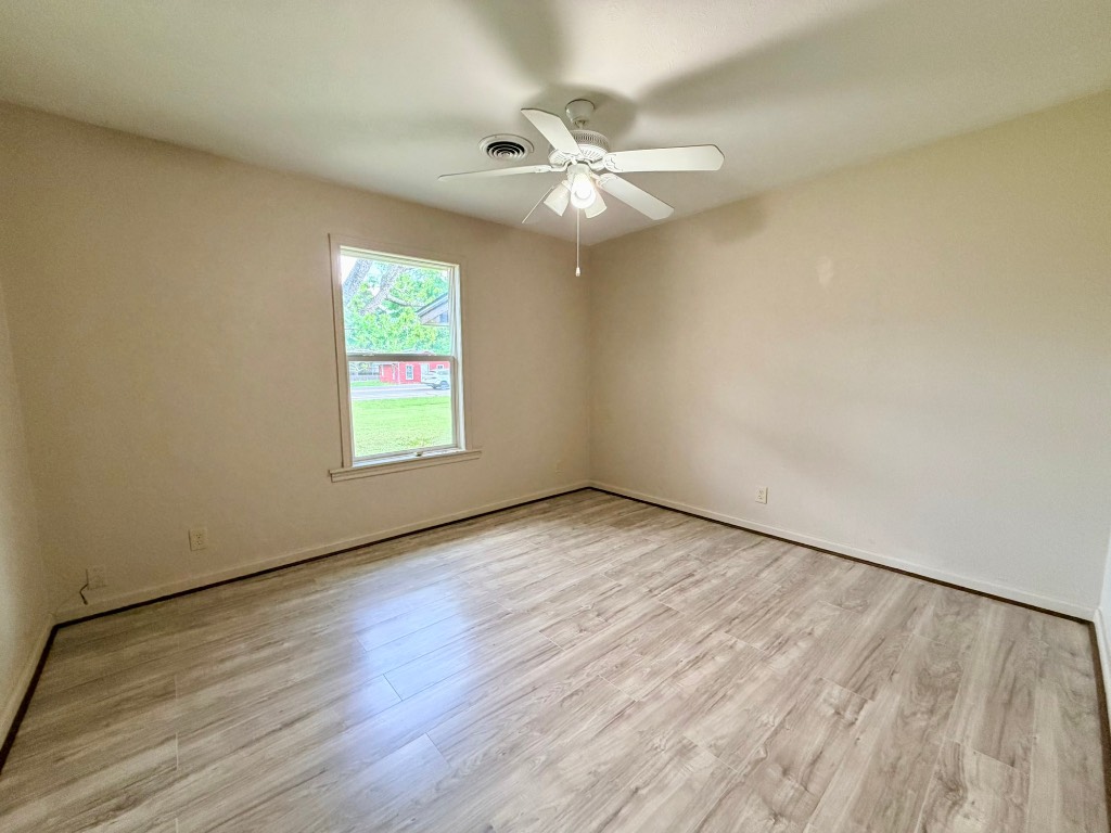 612 Keith Street Kennard, TX 75847 - Photo 11 of 15 an empty room with wooden floor chandelier fan and windows