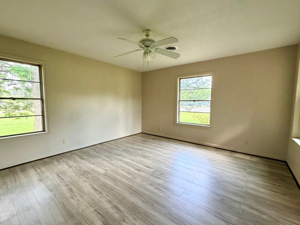 612 Keith Street Kennard, TX 75847 - Photo 14 of 15 an empty room with wooden floor windows and fan