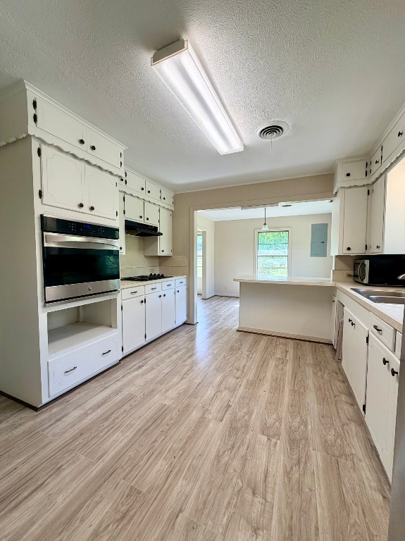 612 Keith Street Kennard, TX 75847 - Photo 7 of 15 a large kitchen with cabinets and wooden floor