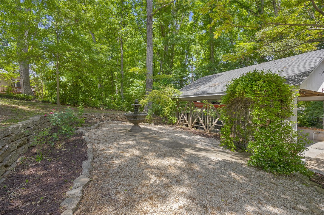218 Northridge Drive Anderson, SC 29621 - Photo 44 of 50 A tranquil garden path with a charming fountain, bordered by natural stone walls and verdant foliage.