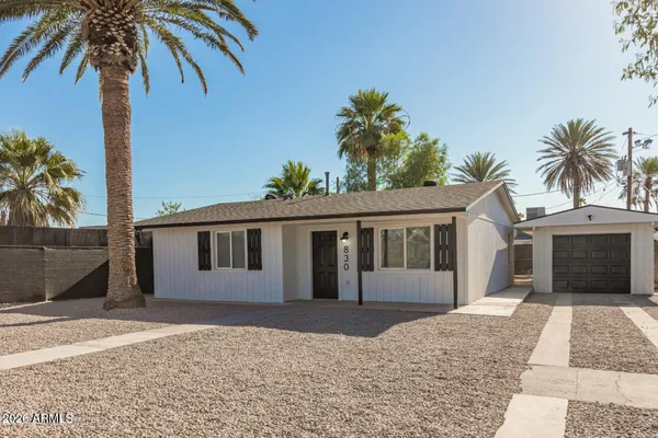 a front view of a house with a yard and potted plants
