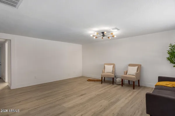 a view of a room with chairs and wooden floor