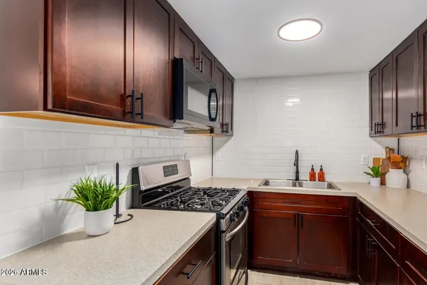 a kitchen with stainless steel appliances a sink stove and cabinets