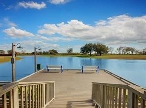 2011 Oak Leaf Court Manvel, TX 77578 - Photo 1 of 28 This photo showcases a serene lakeside view from a wooden deck, complete with benches and picturesque scenery. Perfect for relaxation and enjoying the outdoors.