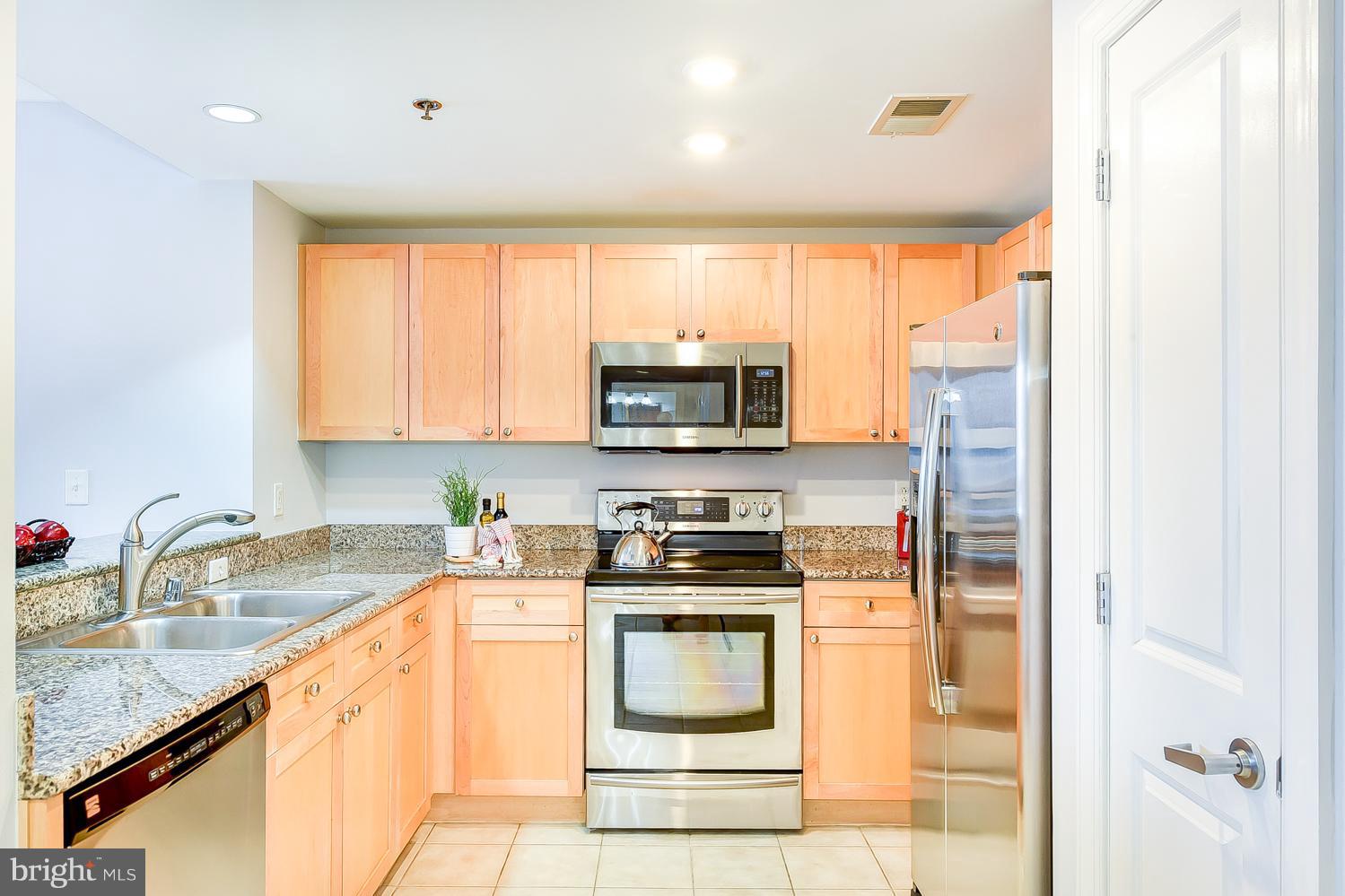 777 7th Street Northwest, Unit 924 Washington, DC 20001 - Photo 4 of 25 a kitchen with a sink a stove and a microwave