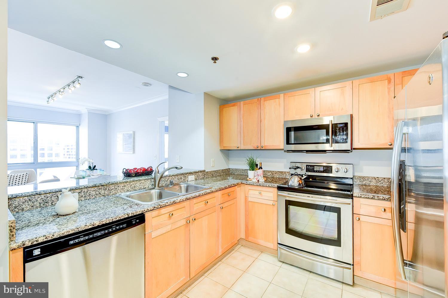 777 7th Street Northwest, Unit 924 Washington, DC 20001 - Photo 5 of 25 a kitchen with granite countertop a sink stainless steel appliances and cabinets