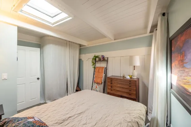 a bedroom with a bed and a large mirror