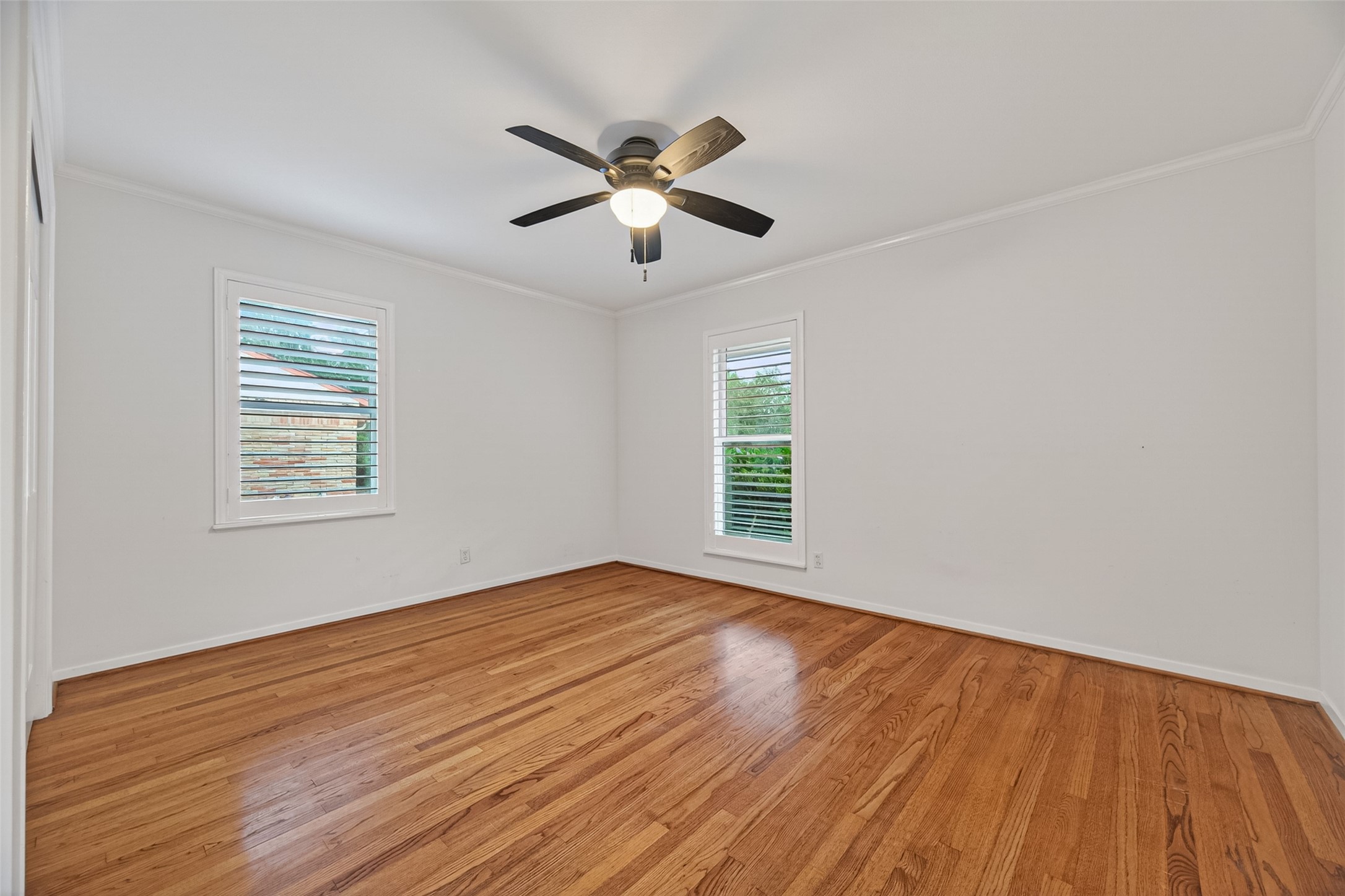 5638 Sanford Road Houston, TX 77096 - Photo 20 of 41 Front-facing secondary bedroom featuring plantation shutters, abundant natural light, and beautiful original hardwood floors.