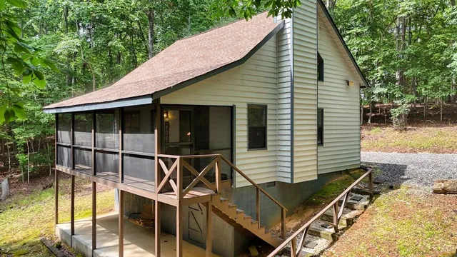 a view of house with backyard tub and trees