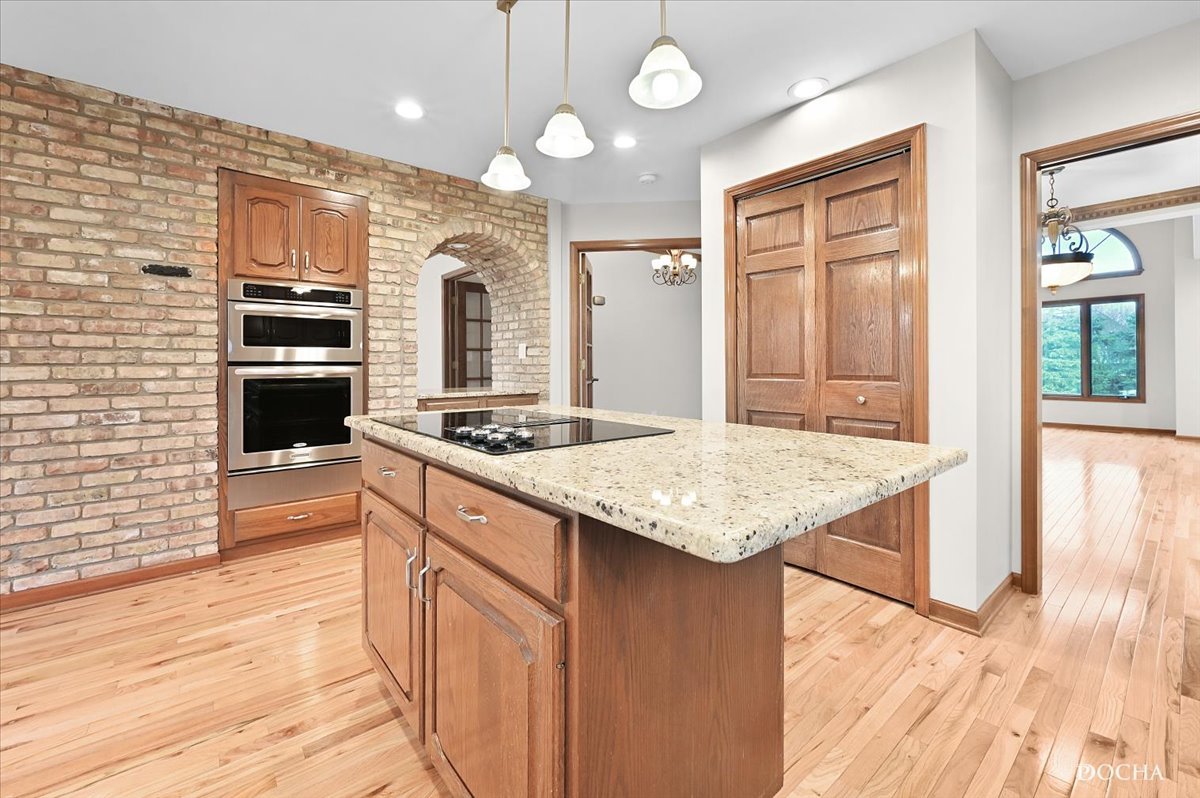 9638 Book Road Naperville, IL 60564 - Photo 11 of 44 a kitchen with kitchen island granite countertop wooden cabinets and a refrigerator