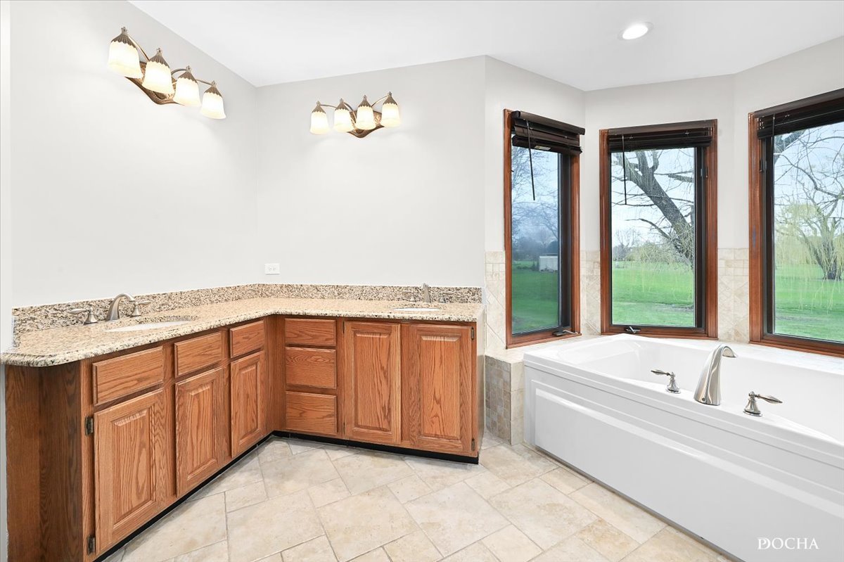 9638 Book Road Naperville, IL 60564 - Photo 24 of 44 a spacious bathroom with a tub sink and mirror