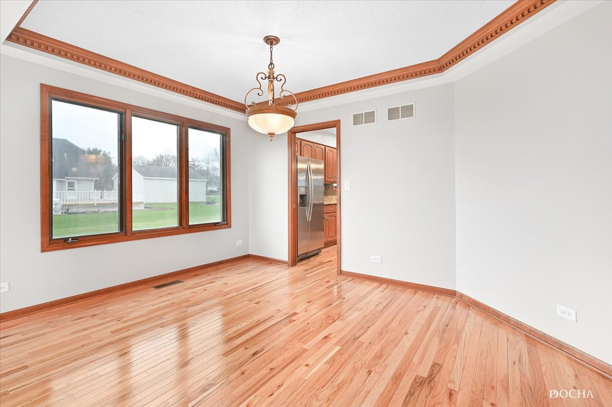 9638 Book Road Naperville, IL 60564 - Photo 8 of 44 a view of an empty room with wooden floor and a window