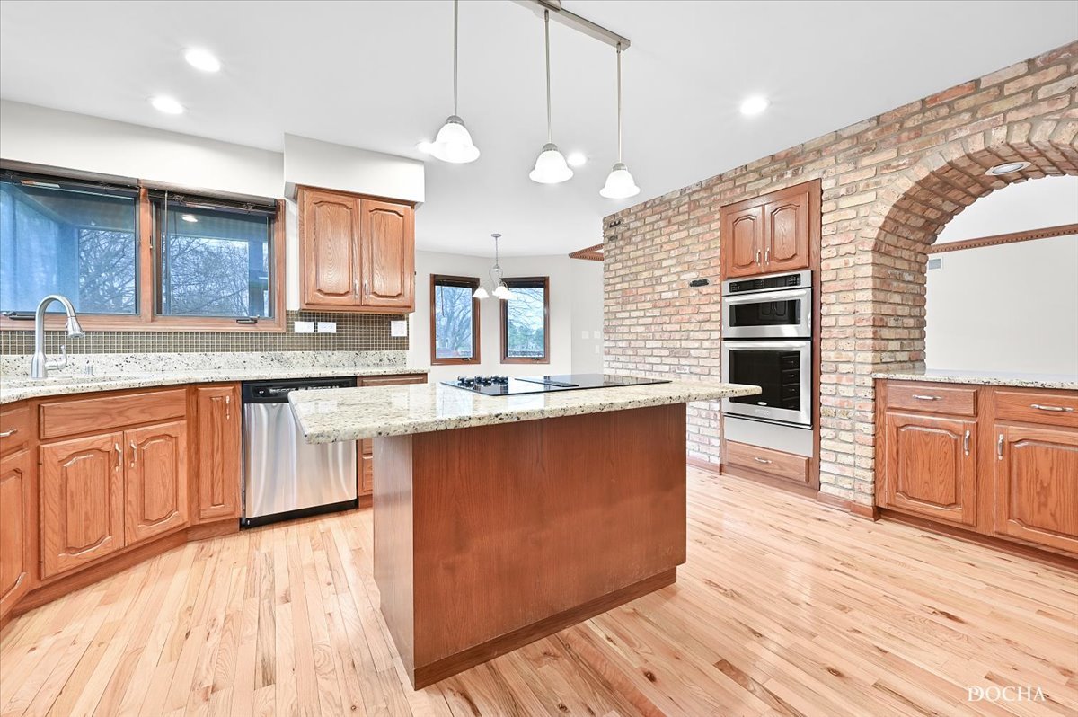 9638 Book Road Naperville, IL 60564 - Photo 10 of 44 a large kitchen with stainless steel appliances kitchen island granite countertop a stove a sink dishwasher and a large countertops with wooden floor