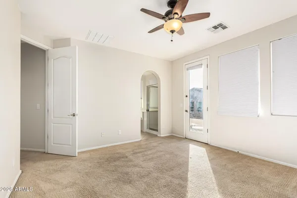 an empty room with closet and a chandelier fan