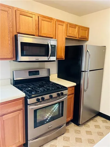 a kitchen with granite countertop wooden cabinets and stainless steel appliances