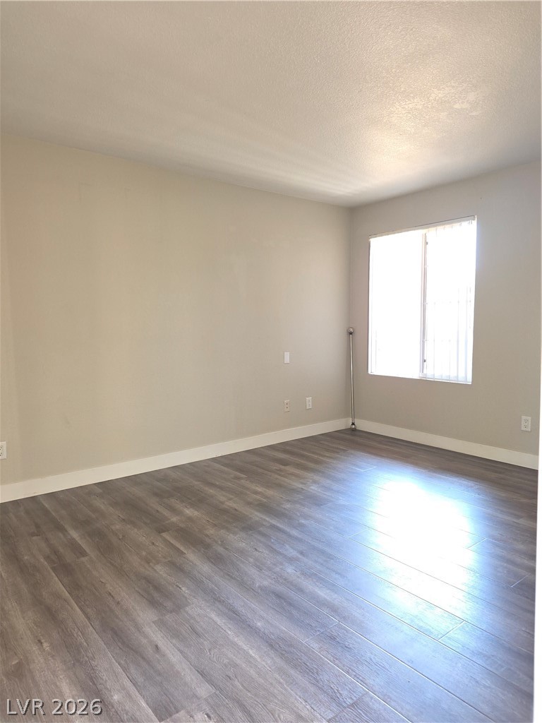 9325 West Desert Inn Road, Unit 239 Las Vegas, NV 89117 - Photo 17 of 29 Unfurnished room with dark wood-type flooring and a textured ceiling