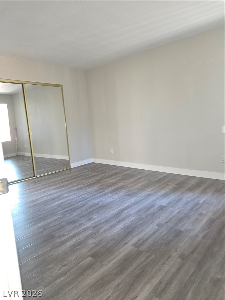 9325 West Desert Inn Road, Unit 239 Las Vegas, NV 89117 - Photo 18 of 29 Unfurnished bedroom featuring dark wood-type flooring and a closet