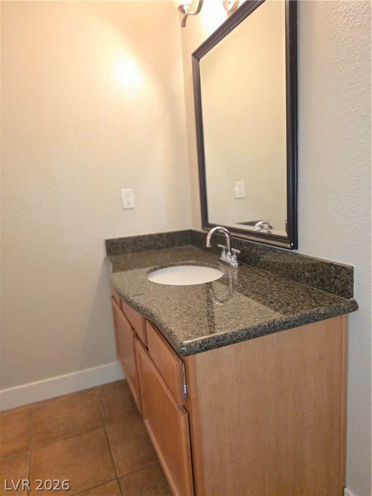 9325 West Desert Inn Road, Unit 239 Las Vegas, NV 89117 - Photo 21 of 29 Half bath featuring a textured wall, vanity, and dark tile patterned flooring