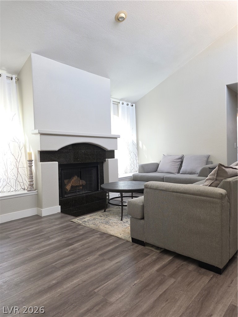 9325 West Desert Inn Road, Unit 239 Las Vegas, NV 89117 - Photo 6 of 29 Living area with dark wood-style flooring, a tile fireplace, and a textured ceiling