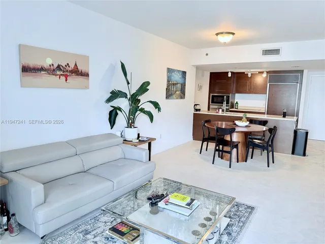 a large bed sitting in a bedroom next to a window with a chair