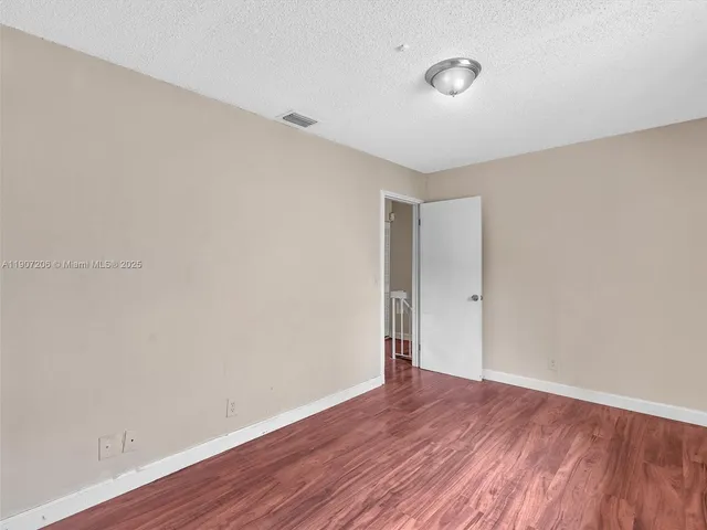 a bedroom with a bed and a lamp on dresser