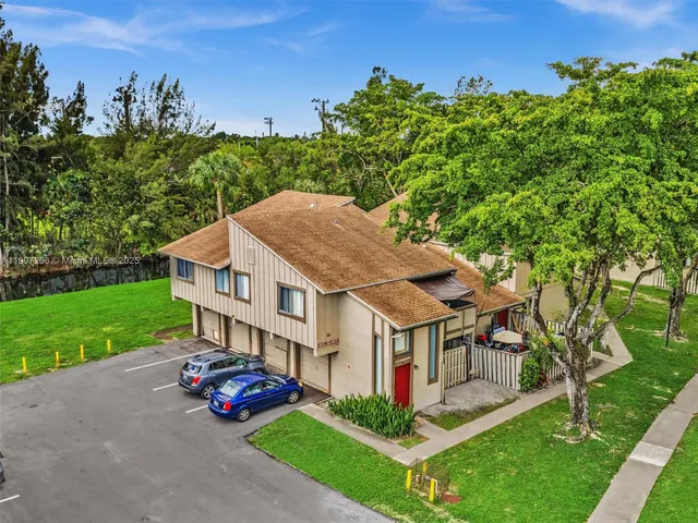 an aerial view of residential houses with outdoor space and lake view