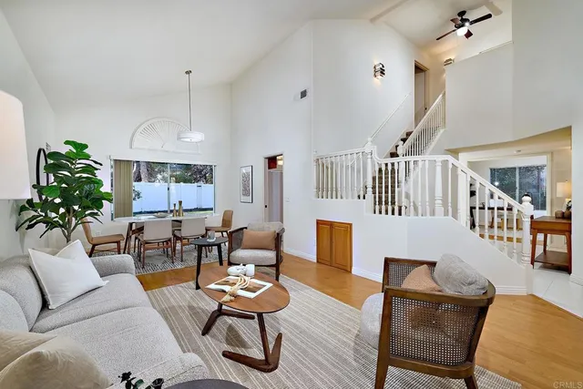a living room with furniture kitchen view and a chandelier