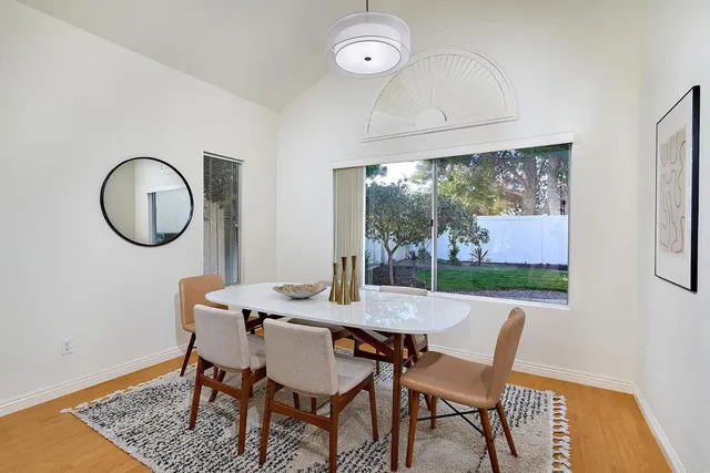 a view of a dining room with furniture a chandelier and wooden floor